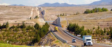 A car and two trucks driving along the highway in Mexico